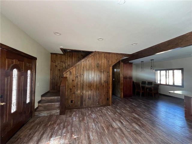 foyer entrance with wood walls and dark hardwood / wood-style flooring