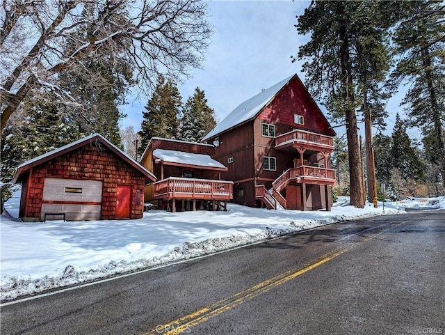 log home featuring a garage, an outdoor structure, and a deck