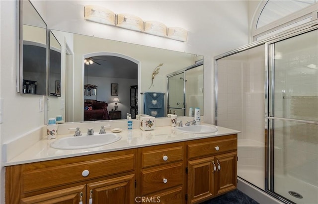 ensuite bathroom with a stall shower, ensuite bathroom, a sink, and a ceiling fan