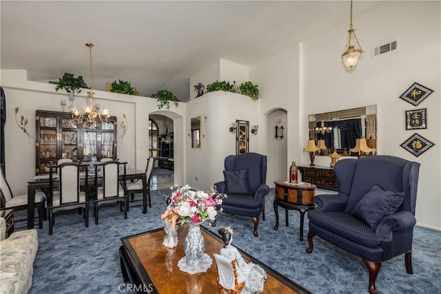 living room with visible vents, an inviting chandelier, arched walkways, high vaulted ceiling, and dark colored carpet