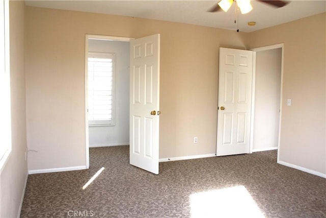 unfurnished bedroom with dark colored carpet and ceiling fan