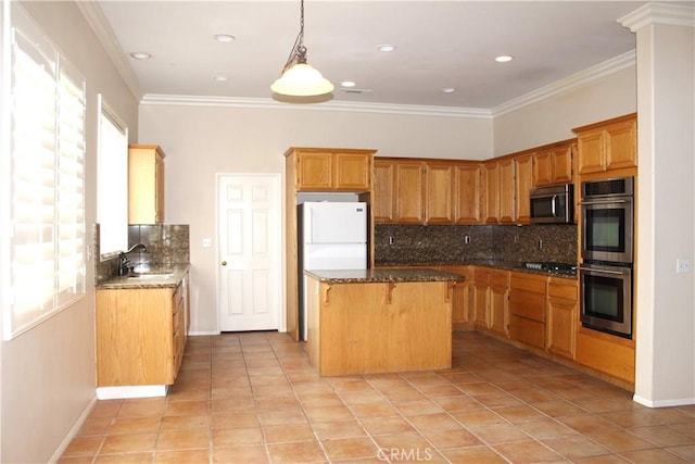 kitchen featuring appliances with stainless steel finishes, a center island, ornamental molding, and backsplash