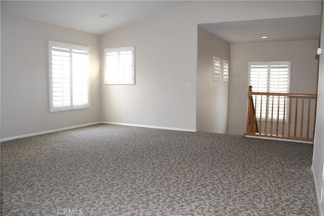 spare room featuring carpet flooring and lofted ceiling