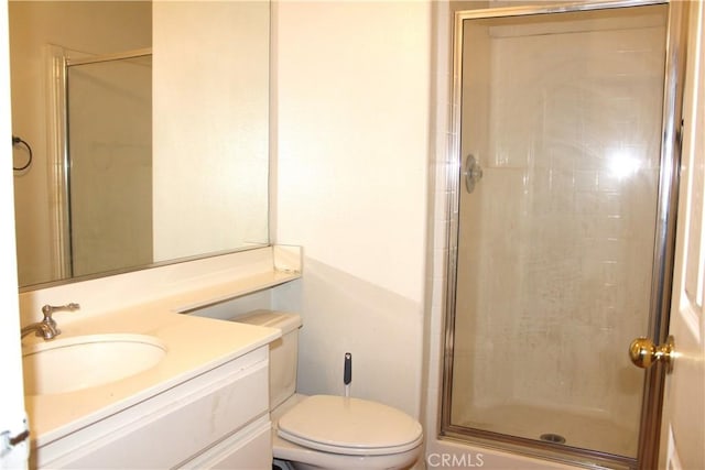 bathroom featuring vanity, an enclosed shower, and toilet