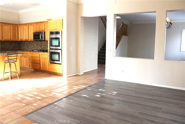 kitchen featuring tasteful backsplash, a breakfast bar, stainless steel appliances, and tile patterned flooring