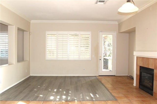 unfurnished living room with tile patterned floors, crown molding, and a tile fireplace