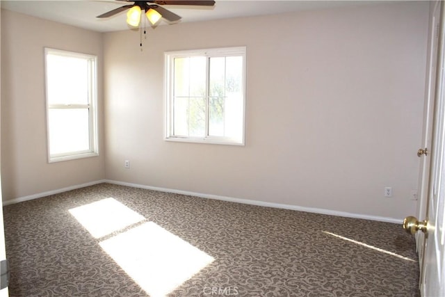 carpeted empty room featuring a wealth of natural light and ceiling fan