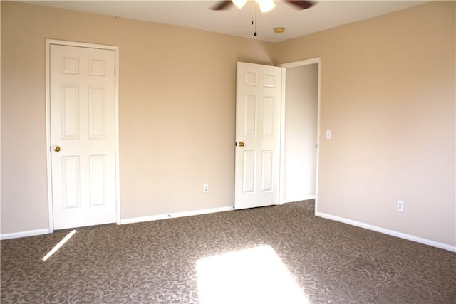 unfurnished bedroom with ceiling fan and dark carpet