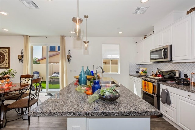 kitchen featuring a center island, sink, stainless steel appliances, and white cabinetry