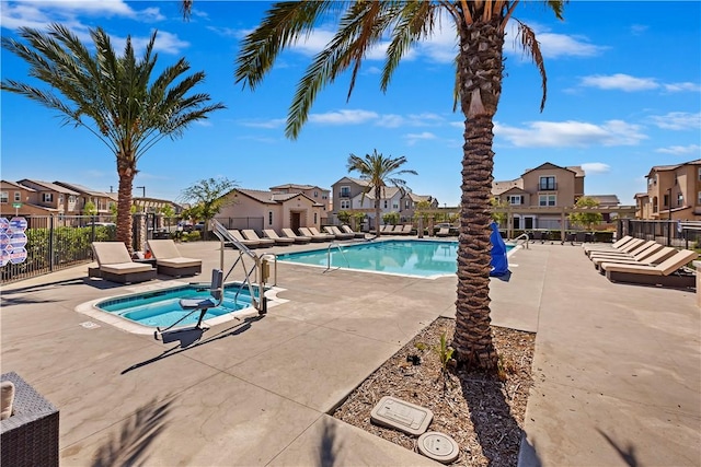 view of swimming pool featuring a hot tub and a patio area