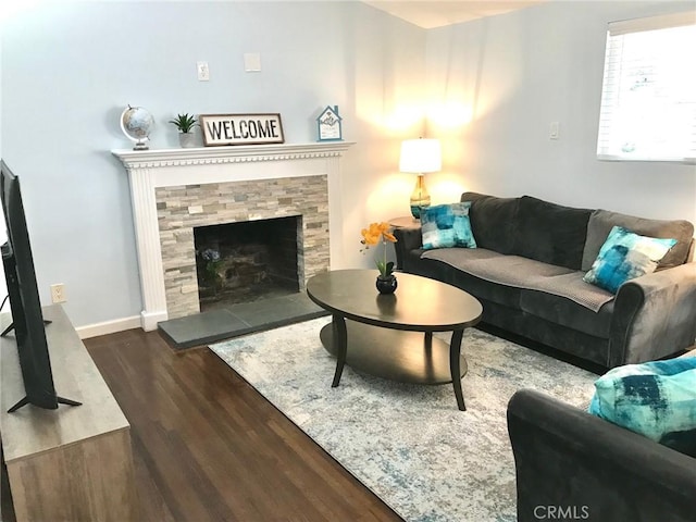 living room with a fireplace and dark wood-type flooring