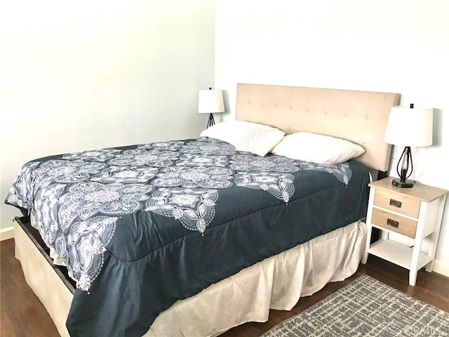 bedroom with dark hardwood / wood-style floors