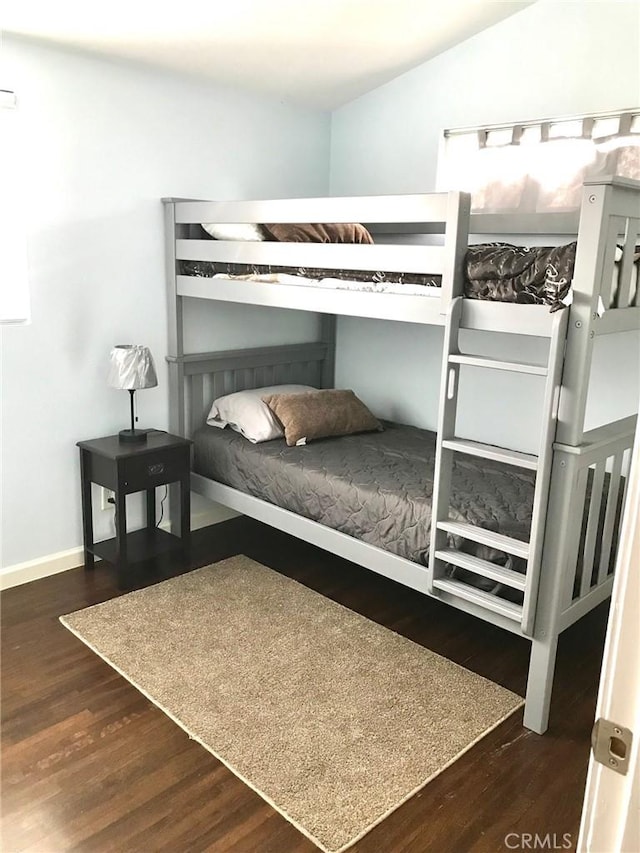 bedroom featuring lofted ceiling and dark wood-type flooring