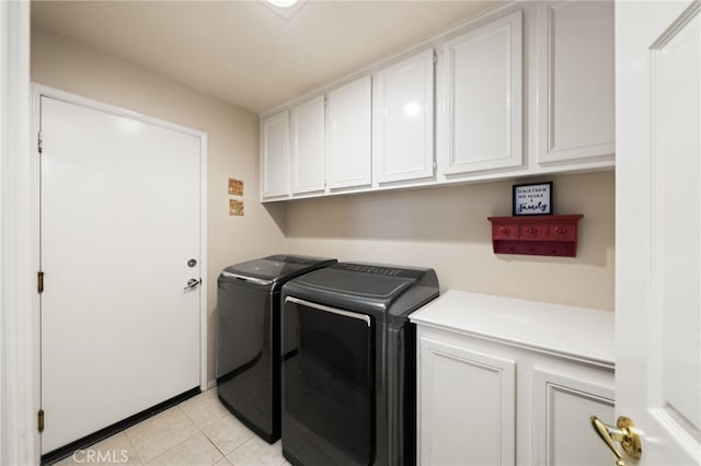 washroom with cabinets, light tile patterned floors, and washer and clothes dryer