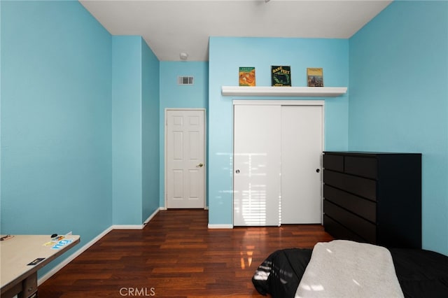 bedroom with a closet and dark hardwood / wood-style floors