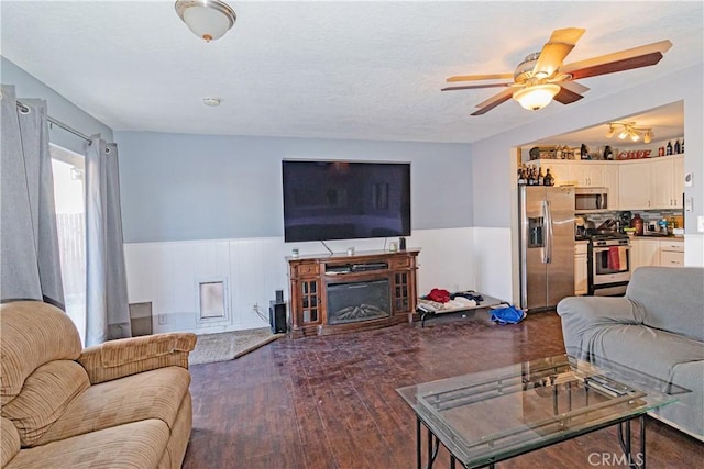 living room with ceiling fan and dark hardwood / wood-style flooring