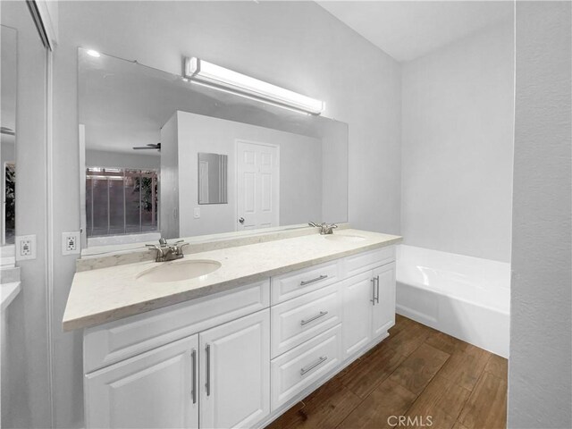 bathroom featuring vanity, a bath, and hardwood / wood-style floors