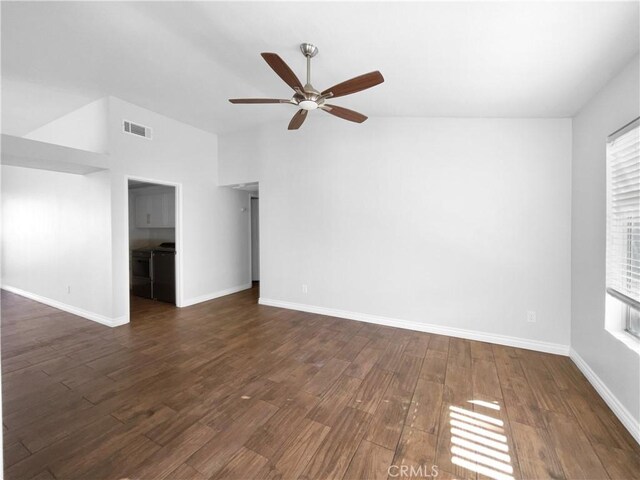 unfurnished room with ceiling fan, a healthy amount of sunlight, dark hardwood / wood-style floors, and vaulted ceiling