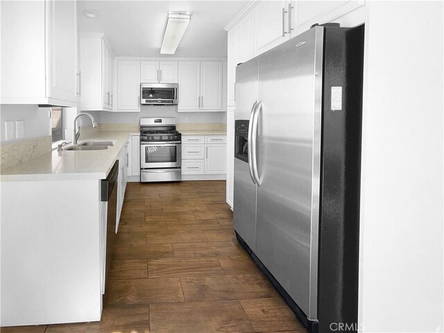 kitchen with white cabinetry, sink, dark wood-type flooring, and appliances with stainless steel finishes