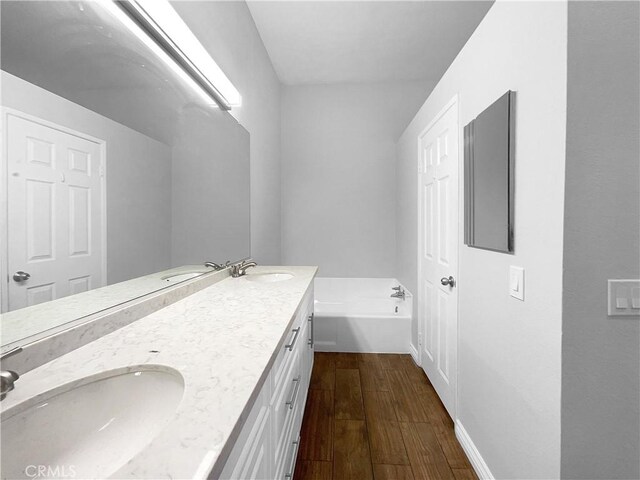 bathroom with vanity, a bathtub, and wood-type flooring