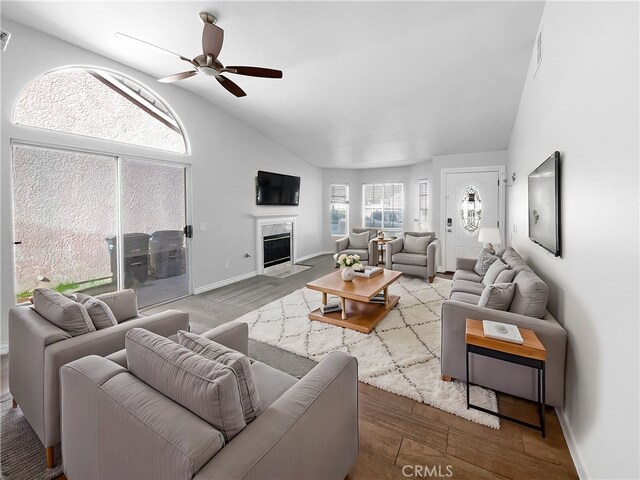 living room with lofted ceiling, hardwood / wood-style floors, and ceiling fan