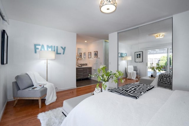 bedroom featuring hardwood / wood-style floors and ensuite bath