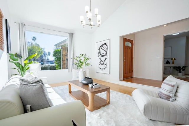 living room featuring lofted ceiling, a chandelier, and wood-type flooring