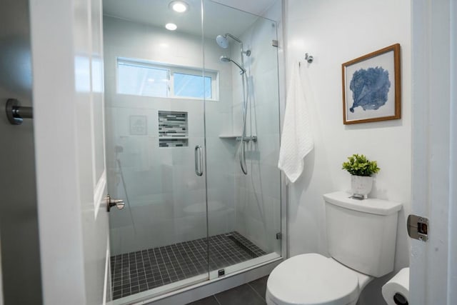 bathroom with tile patterned flooring, an enclosed shower, and toilet