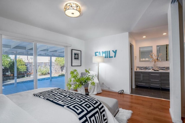 bedroom featuring access to exterior, dark hardwood / wood-style flooring, and connected bathroom