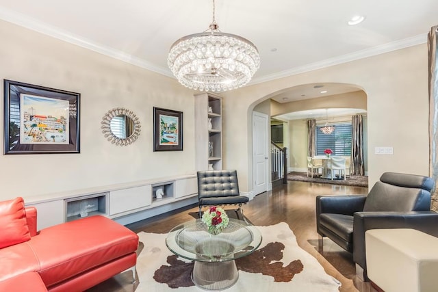 living room with dark hardwood / wood-style flooring, crown molding, and an inviting chandelier