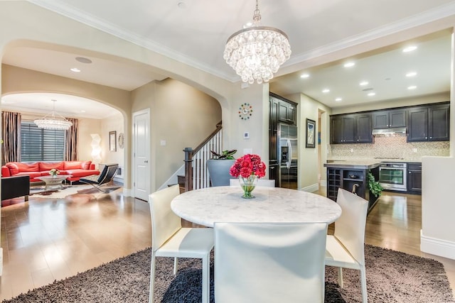 dining room with ornamental molding, a chandelier, and hardwood / wood-style flooring