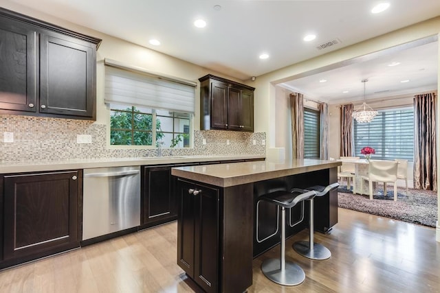 kitchen featuring an inviting chandelier, dishwasher, a center island, light hardwood / wood-style floors, and hanging light fixtures