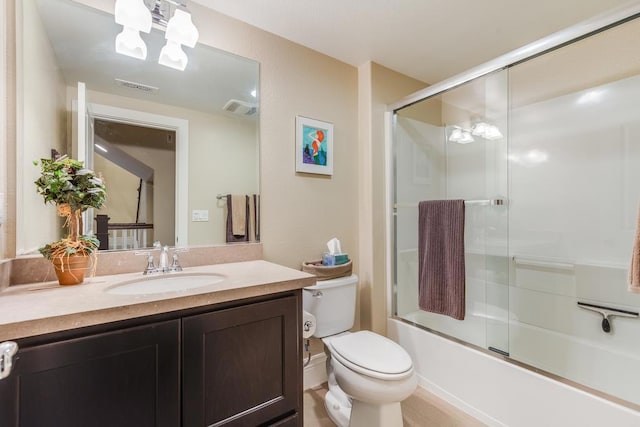 full bathroom with vanity, toilet, and shower / bath combination with glass door