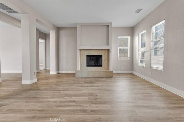 unfurnished living room with light hardwood / wood-style floors and a high end fireplace