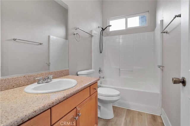 full bathroom with shower / tub combination, hardwood / wood-style floors, vanity, and toilet