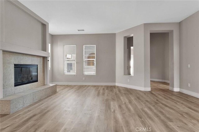 unfurnished living room featuring light hardwood / wood-style floors and a fireplace