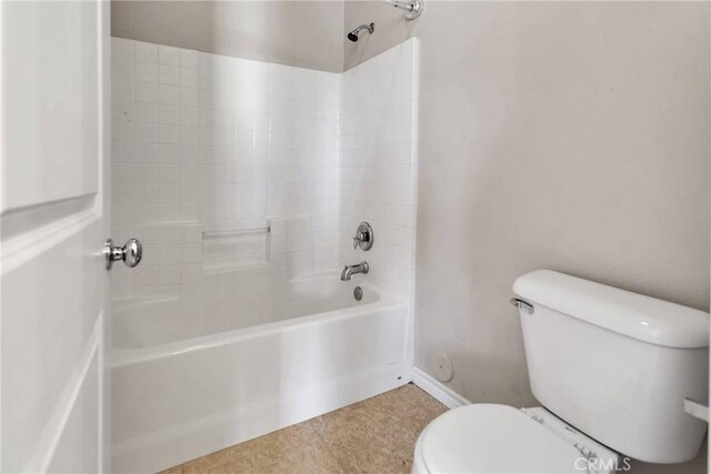 bathroom with bathing tub / shower combination, tile patterned flooring, and toilet