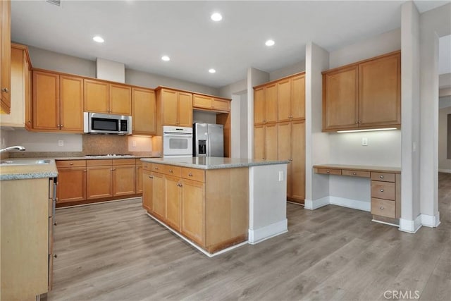 kitchen featuring a center island, light hardwood / wood-style flooring, stainless steel appliances, and sink