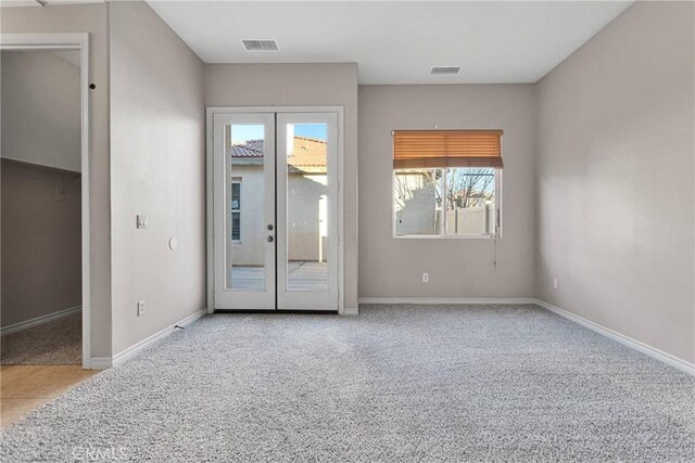 carpeted empty room featuring french doors