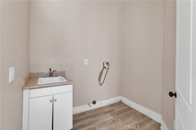 12573 Cabazon Ct, Apple Valley, CA 92308 - clothes washing area featuring light wood finished floors, baseboards, cabinet space, and a sink