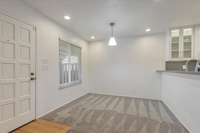 unfurnished dining area with sink and carpet floors