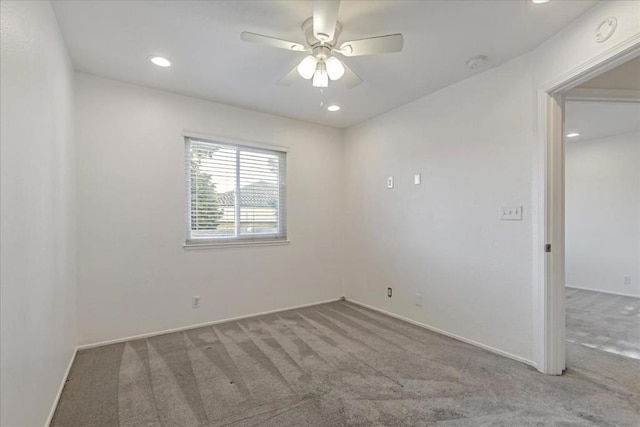 carpeted spare room featuring ceiling fan