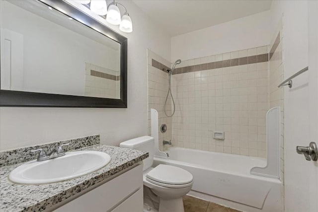 full bathroom featuring toilet, tiled shower / bath, tile patterned floors, and vanity