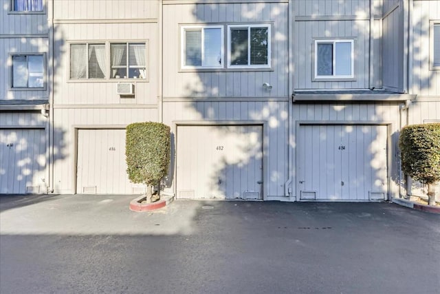 exterior space featuring a wall mounted AC and a garage