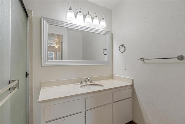 bathroom with walk in shower and vanity