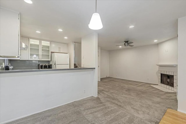 kitchen with white fridge, hanging light fixtures, light colored carpet, ceiling fan, and white cabinetry