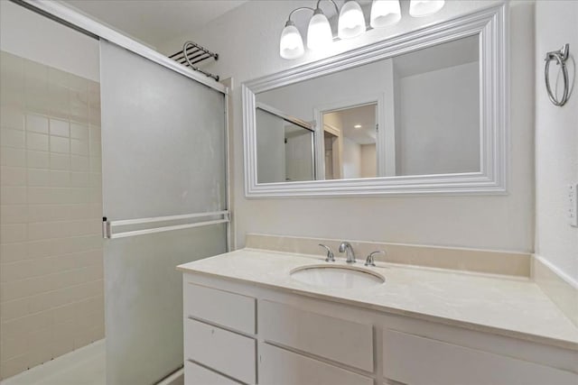 bathroom with a shower with door and vanity