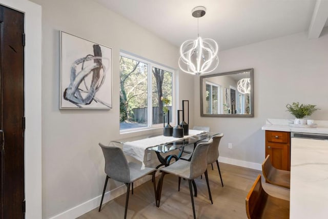 dining area with light hardwood / wood-style floors and an inviting chandelier