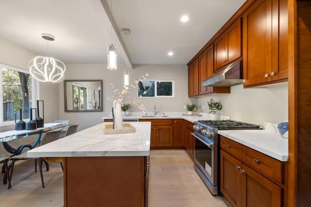 kitchen with a notable chandelier, pendant lighting, light hardwood / wood-style flooring, high end stainless steel range oven, and light stone counters