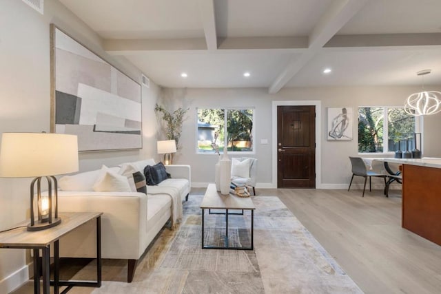 living room featuring beam ceiling, light wood-type flooring, and a chandelier